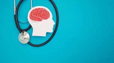 Mavi arka planda bir beyin şekli sembolü ve steteskop. Alzheimer, Parkinson, bunama, felç, nöbet ya da akıl sağlığı. Nöroloji ve Psikoloji