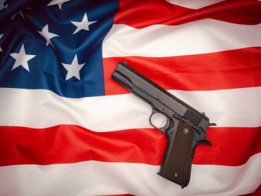 Amerikan bayrağının arka planında bir tabancanın üst görüntüsü. Yakın plan fotoğraf.