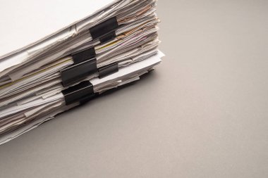 Gri arkaplanda klasör klipsleri olan bir yığın belge. Mesaj için yer var. Yakın plan fotoğraf.