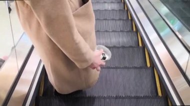 Havaalanındaki yürüyen merdivenden inen insanlarla birlikte.