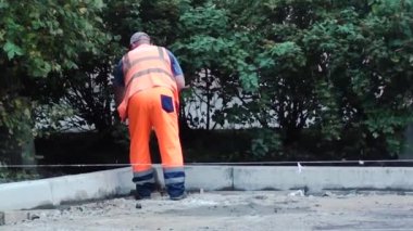 İşçi yolun bir kısmını onarıyor.