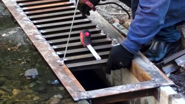 Bir işçi yağmur kanalını kurar ve kaynak yapar