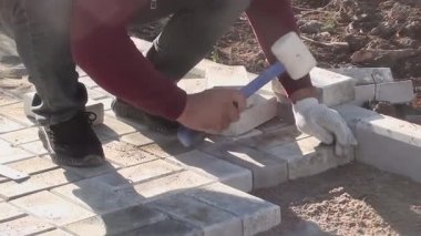 Bir işçi kaldırım levhalarını sokağa serer.