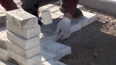 Bir işçi kaldırım levhalarını sokağa serer.