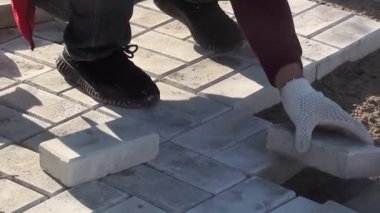 Bir işçi kaldırım levhalarını sokağa serer.