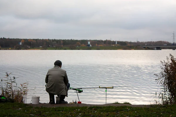 一个秋天的早晨 一个孤零零的渔夫背对着摄像机 独自在河边沉默寡言地钓鱼 — 图库照片