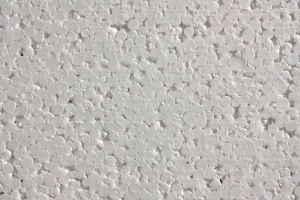 Horizontal close-up photo with a texture of white synthetic Polystyrene foam sheet