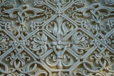 Taş bir duvarda eski bir alçı deseni var.
