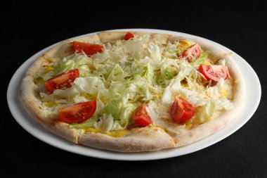 Arka planda güzel kokulu ve sıcak bir pizza.