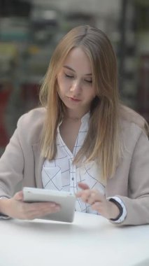 Dikey video bir kafede çalışan bir kız sitesi uzmanı sosyal ağlara, postalara, mektuplara ve tabletlere bakar. iç mekanda modern teknolojileri kullanan kasvetli ve öfkeli bir kız.