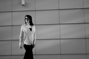 Şirket fotoshoot 'u için fotoğraf çeken kadın patron, iş yerindeki başarılı kadın, güneş gözlüklü kadın alışveriş merkezinin yanındaki siyah beyaz fotoğraflı kadın.