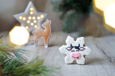 Yılbaşı zencefilli çörekler Noel yıldızı şeklinde kar taneleri şeklinde boğa, 2021 Noel sembolleri, beyaz bir masa üzerinde yeni yıl dekoru, yatay