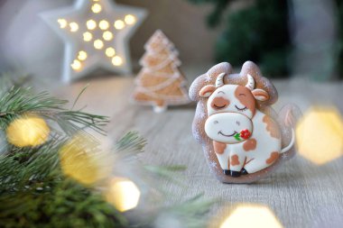Noel boğası şeklinde zencefilli çörekler, 2021 Noel sembolleri, beyaz bir masa üzerinde yeni yıl dekoru, yatay.