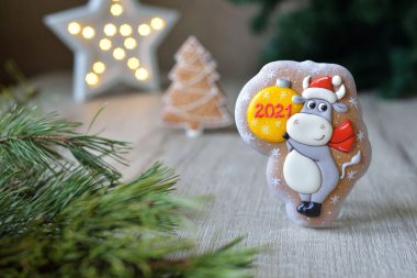 Noel boğası şeklinde zencefilli çörekler, 2021 Noel sembolleri, beyaz bir masa üzerinde yeni yıl dekoru, yatay.