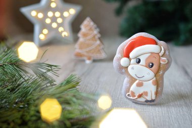 Noel boğası şeklinde zencefilli çörekler, 2021 Noel sembolleri, beyaz bir masa üzerinde yeni yıl dekoru, yatay.