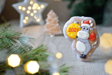 Noel boğası şeklinde zencefilli çörekler, 2021 Noel sembolleri, beyaz bir masa üzerinde yeni yıl dekoru, yatay.
