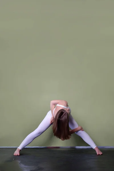 若い茶色の髪の女の子Igi Pose Parivrata Prasarita Padottanasana ねじれとは別に足を広げて曲げる テキストの空間 — ストック写真