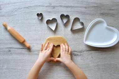 Aileler için Sevgililer Günü için çocuklardan zencefilli ekmek yapıyor. 4-14 yaş arası çocuklar için yemek pişirme eğitimi. İyi motor becerilerin erken gelişimi. Adım adım. 2. adım yukarıdan görünüm