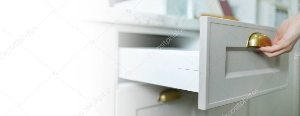 Banner Home improvement concept. young girl designer opens a drawer of a kitchen cabinet in a shop salon