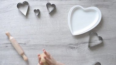 Çocukların elleri kurabiye için hamur yoğurur. Aileler için Sevgililer Günü için çocuklardan zencefilli ekmek yapıyor. Çocuklar için yemek pişirme eğitimi. İnce motor becerilerin erken çocuk gelişimi