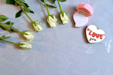 Altın mücevher için pembe boş kutu. Beyaz güllü gri arka planda bir hediye olarak. Düğün anı, yıldönümü, nişan, ya da Sevgililer Günü. Mutlu gün