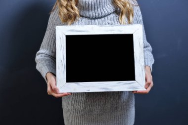 Beyaz ahşap bir çerçeve tutan mutlu genç kız.