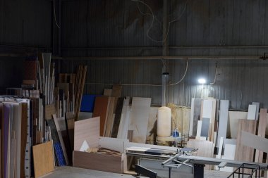 Marangoz atölyesinin arkaplan görüntüsü: üretim ekipmanları, çeşitli ahşap işleme araçları, tahta tahtalar ve fabrikadaki mobilya parçaları. Marangozların atölyesinde mobilya yapmak için kullanılan makine.