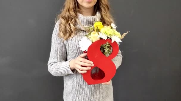 一个穿着灰色毛衣的金发女孩手里拿着一束花在八号录像里 国际妇女日礼物 — 图库视频影像