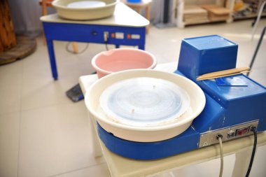 Boş bir mavi çömlekçi çarkı çamurdan lepui çömlek çalışması için hazırlanır. Bir ustadan çömlek atölyesinde kil ürünleri yapmak için araçlar.