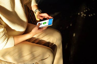 Smartphone COVID-19 için geçerli dijital aşı sertifikası sertifikasını sert gölgeli kadınların elinde gösteriyor. Aşı, hastalık dokunulmazlığı pasaportu, sağlık ve güvenli seyahat kavramları.