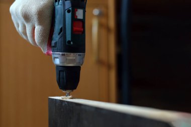 Mor renkte, bir adam MDF mobilyalarını kaplamak için boş bir delik açıyor. MDF mobilya montaj kavramı.