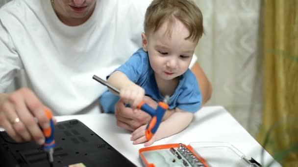 Glücklicher Vater Und Sohn Sitzen Kniend Weißen Tisch Und Reparieren — Stockvideo