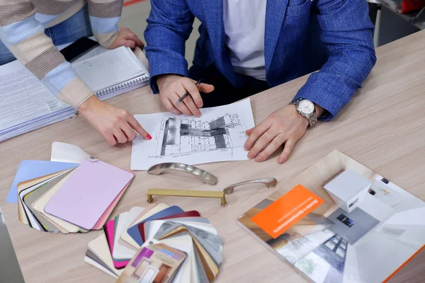 Tasarımcı, kaplamalı MDF 'den yapılmış mutfak setinin düzenini ve mobilya kulpu seçimini ofiste müşterisi ile onaylar..