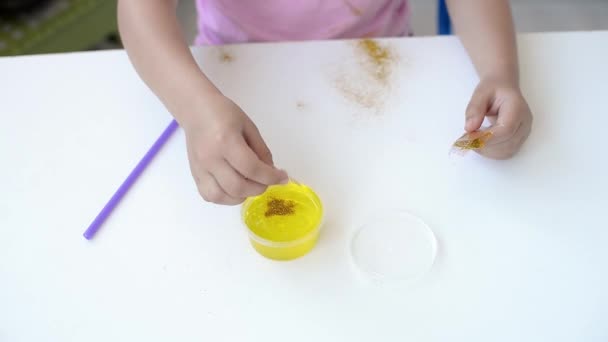 Fille Dans Shirt Rose Ajoute Granules Saupoudrer Boue Jaune Enfant — Video