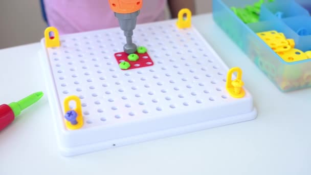 Zbliżenie Dziecka Grającego Puzzle Konstruktora Edukacyjnego Dla Dzieci Śrubokrętem Śrubokrętem — Wideo stockowe