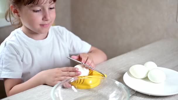 ライフスタイルの未就学児の女の子は台所で食べ物を調理します 廃材からの日常生活における優れた運動能力の開発 黄色の卵カッターで卵を切り取り — ストック動画