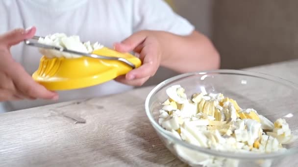 ライフスタイルの未就学児の女の子は台所で食べ物を調理します 廃材からの日常生活における優れた運動能力の開発 黄色の卵カッターで卵を切り取り — ストック動画
