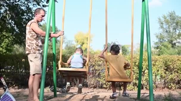 Apa Hintán Gurítja Gyerekeket Fiú Lánya Játszótéren Közös Séta Gyerekekkel — Stock videók