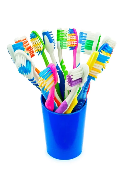 Colorful toothbrushes in blue cup — Stock Photo, Image