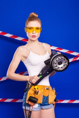 Koruyucu bir kask içinde bir profesyonel yapı aracı ile mavi bir arka plan Oluşturucu kız