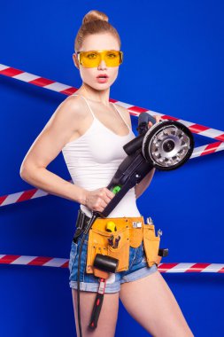 Koruyucu bir kask içinde bir profesyonel yapı aracı ile mavi bir arka plan Oluşturucu kız