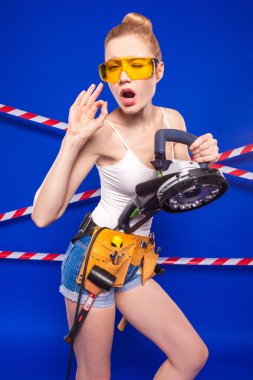 Koruyucu bir kask içinde bir profesyonel yapı aracı ile mavi bir arka plan Oluşturucu kız