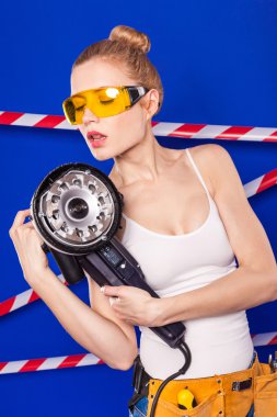 Koruyucu bir kask içinde bir profesyonel yapı aracı ile mavi bir arka plan Oluşturucu kız