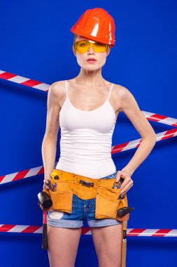 Koruyucu bir kask içinde bir profesyonel yapı aracı ile mavi bir arka plan Oluşturucu kız