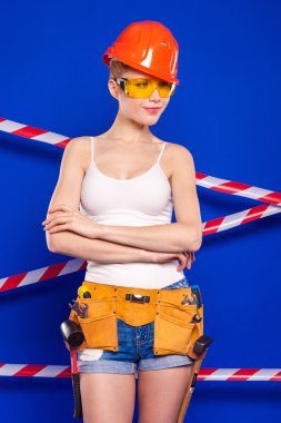 Koruyucu bir kask içinde bir profesyonel yapı aracı ile mavi bir arka plan Oluşturucu kız