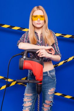 Koruyucu bir kask içinde bir profesyonel yapı aracı ile mavi bir arka plan Oluşturucu kız