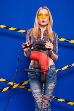Koruyucu bir kask içinde bir profesyonel yapı aracı ile mavi bir arka plan Oluşturucu kız