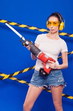 Elinde elektrikli bir araç ile mavi bir arka plan üzerinde seksi esmer Oluşturucu