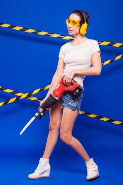 Elinde elektrikli bir araç ile mavi bir arka plan üzerinde seksi esmer Oluşturucu