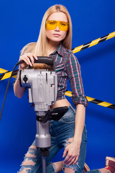 Budowniczy dziewczyna na niebieskim tle z narzędzie budowania profesjonalnego w kask ochronny — Zdjęcie stockowe